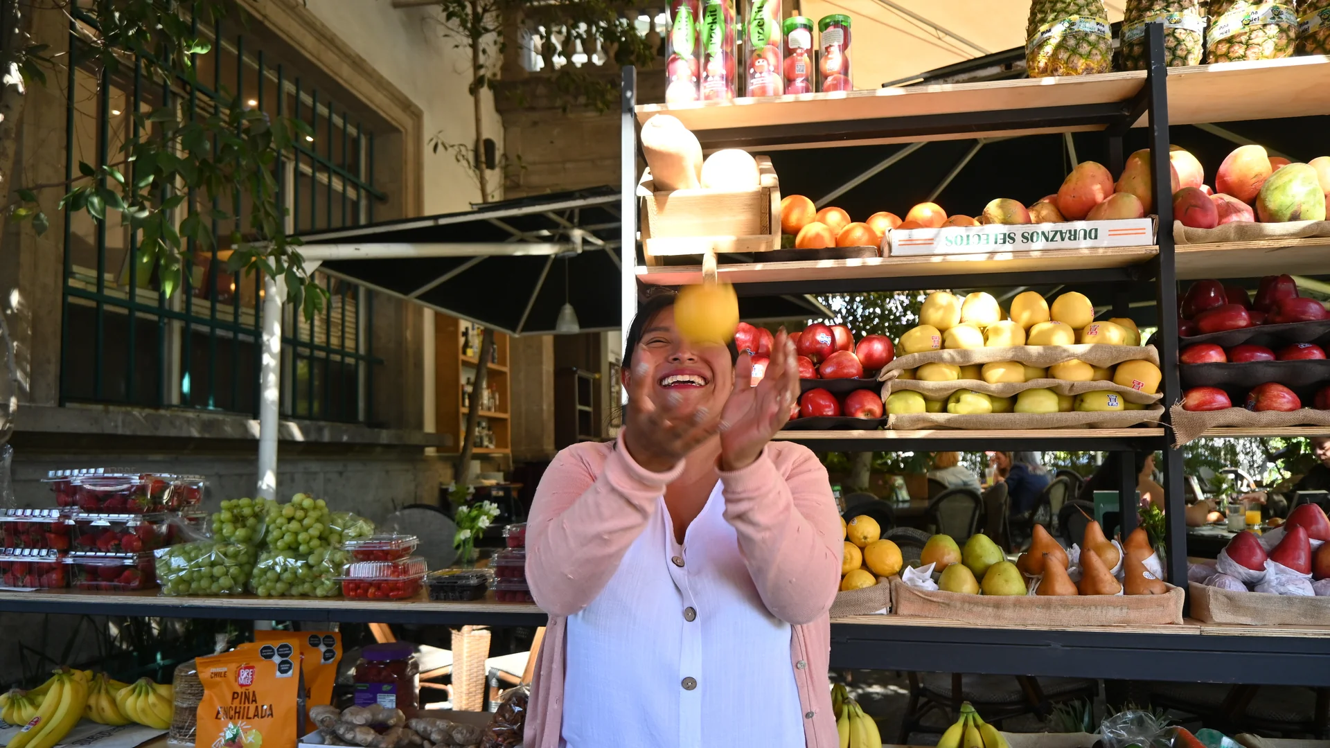 Sthefany Bonifacio lanza una fruta al aire en su puesto de la Frutería Pepe