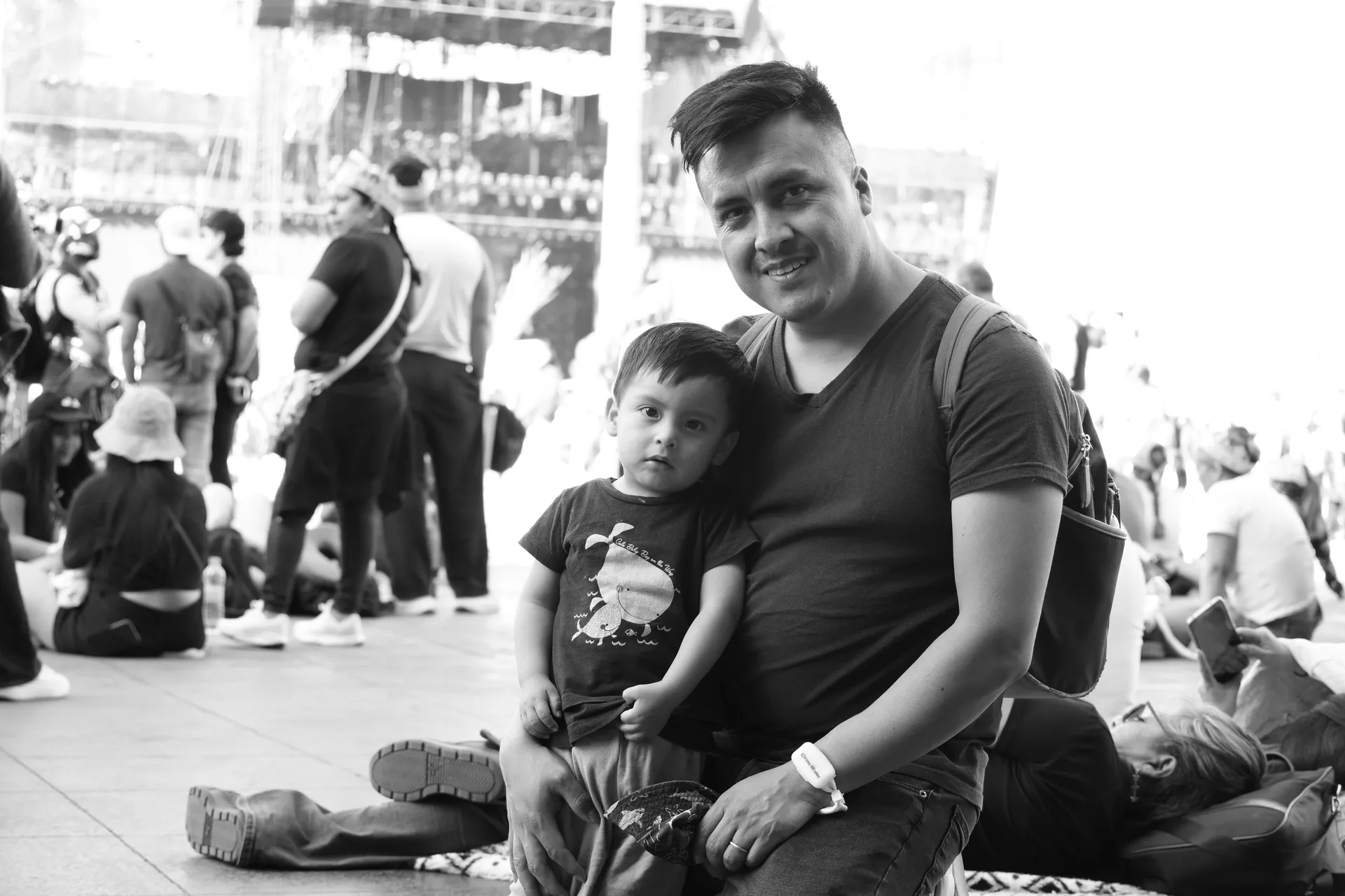 Padre sentado con su hijo pequeño esperando el concierto en el Zócalo