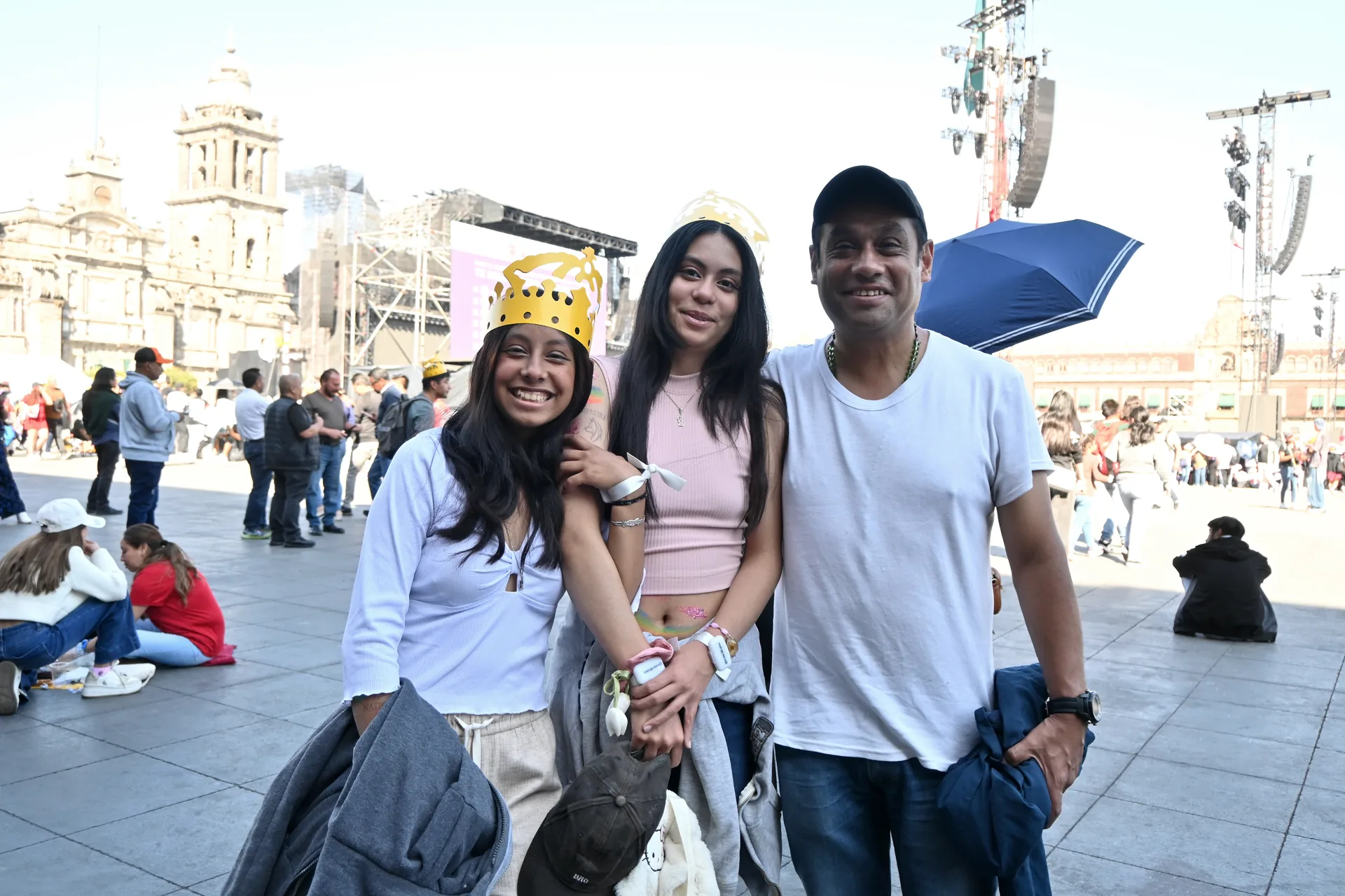 Padre con dos hijas sentados en la plancha del Zócalo, esperando el inicio del concierto de Shakira bajo el sol de marzo